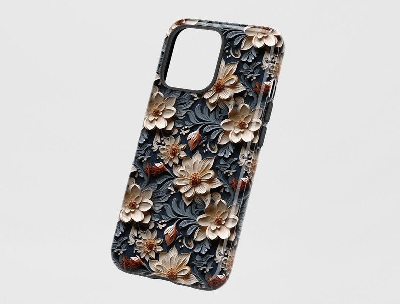 May include: A black phone case with a floral design. The flowers are white and brown with a 3D effect. The background is dark blue.