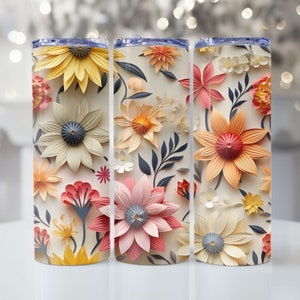 May include: Three stainless steel tumblers with a floral design. The tumblers feature a white background with colorful paper flowers in shades of pink, yellow, and orange.