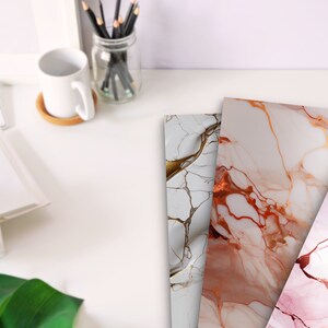 May include: Three sheets of decorative paper with a marble pattern. The paper has a white background with gold and pink veins. The paper is perfect for crafting, scrapbooking, and other creative projects.