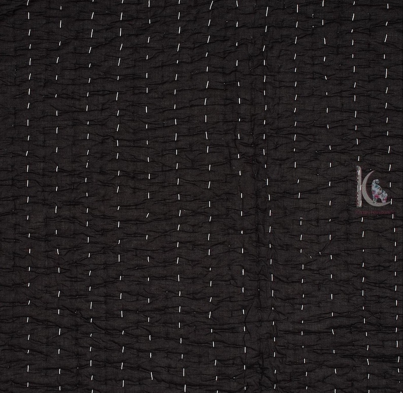 May include: Black quilted fabric with white stitching in a vertical pattern. The fabric has a textured appearance, with a crinkled surface. The stitching is evenly spaced, creating a grid-like design. The overall aesthetic is simple and elegant.