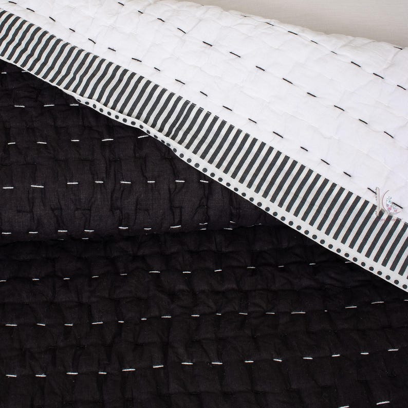 Texture of the lightweight Indian cotton fabric in a solid black, reversible Kantha quilt