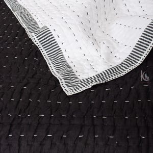 handstitched Kantha pattern on a solid black, lightweight Indian cotton quilt