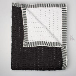 reversible solid black Kantha quilt, highlighting the subtle textural pattern created by the handstitching