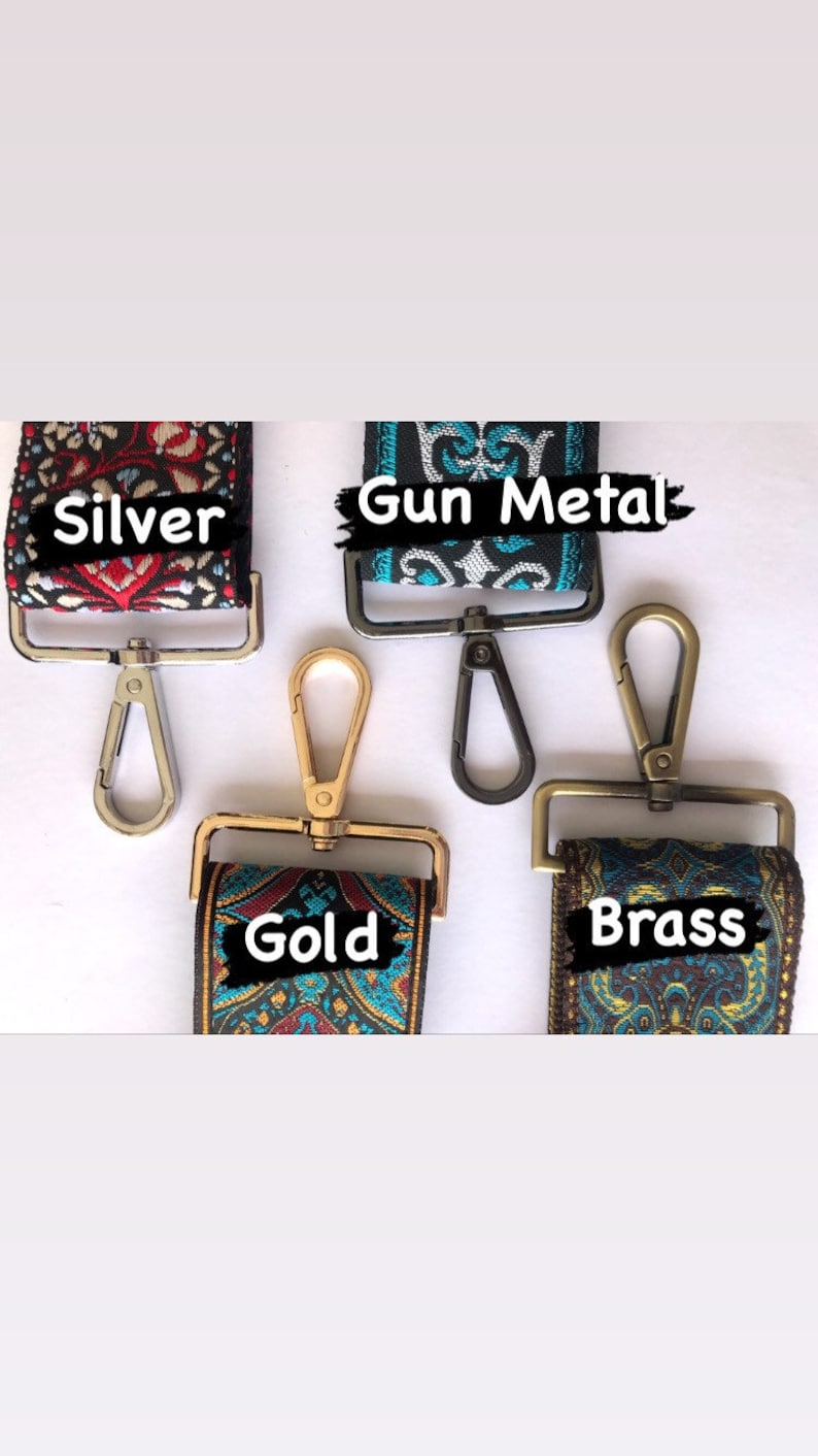 May include: Four different coloured metal clasps for a bag strap. The clasps are silver, gun metal, gold, and brass. Each clasp is attached to a colourful patterned fabric strap.