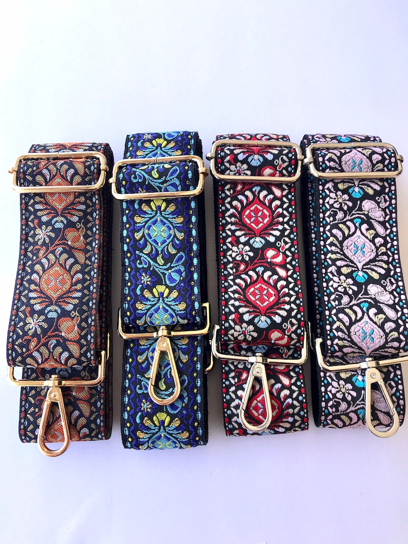 May include: Four colourful woven fabric straps with gold metal clasps. The straps have a floral pattern and are suitable for bags or purses.