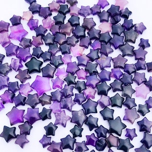 Peut inclure: Une grande collection de pierres d'améthyste en forme d'étoile de couleur violette. Les pierres sont de différentes nuances de violet et ont une texture naturelle et rugueuse.