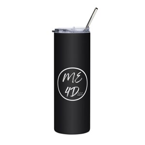 May include: A matte black cylindrical tumbler featuring a clear plastic lid and a silver metal straw. Centered on the front is a white circular graphic containing the text ME 4Dlc in a stylized, handwritten font. The design is clean and minimalist.