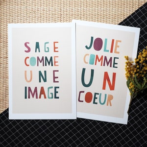 May include: Two cards with colorful text on a beige background. The card on the left says 'Sage comme une image' and the card on the right says 'Jolie comme un coeur'.