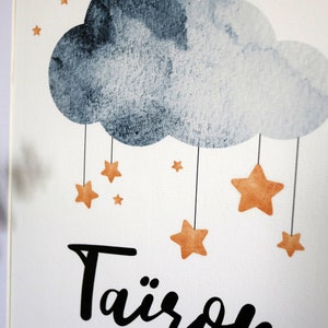 Puede incluir: Una impresi&oacute;n de acuarela con una nube gris y estrellas naranjas colgando de ella. El texto "Tairs" est&aacute; escrito en cursiva negra en la parte inferior de la impresi&oacute;n.
