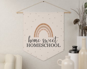 Puede incluir: Una pancarta de pennant beige con un arcoíris marrón y beige y el texto "home sweet homeschool" en negro. La pancarta tiene un patrón de lunares blancos.