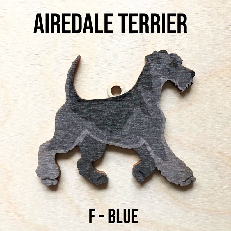May include: A black and gray wooden Airedale Terrier dog ornament with a hole for hanging. The ornament is labeled "F - BLUE".