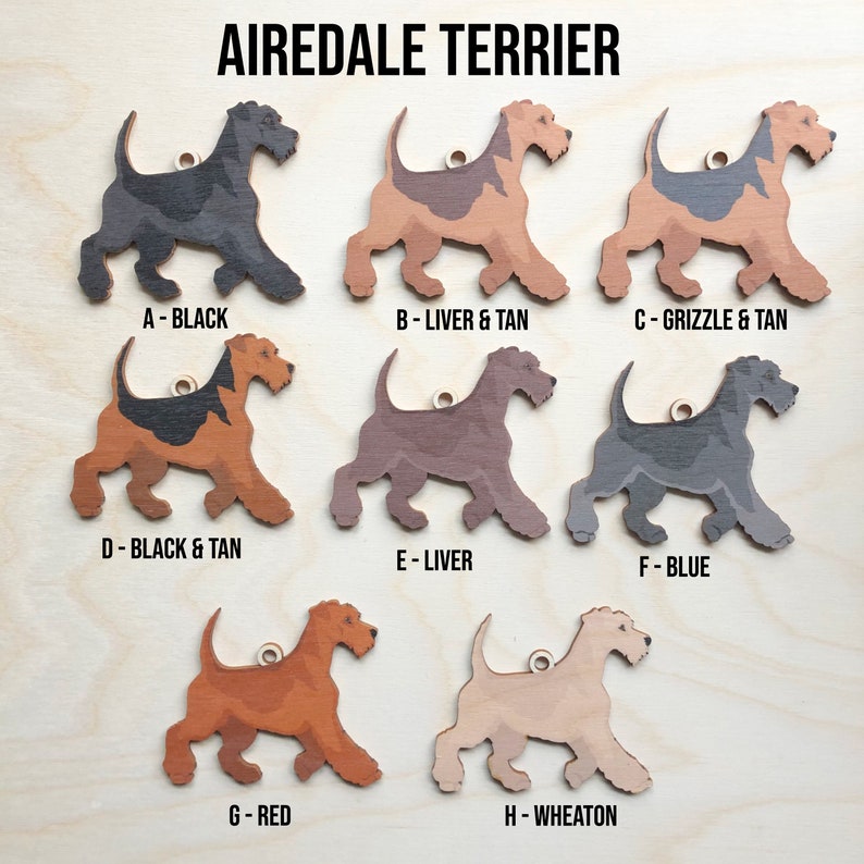 May include: Eight wooden Airedale Terrier dog ornaments in different colors: black, liver and tan, grizzle and tan, black and tan, liver, blue, red, and wheaten.