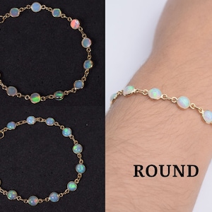 May include: A gold chain bracelet with round opal stones. The bracelet is shown on a model's wrist. ROUND