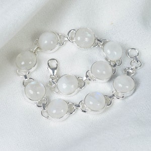 May include: A silver bracelet with white moonstone beads. The bracelet has a lobster clasp closure.