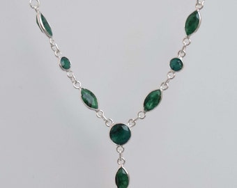 May include: A silver necklace with a green gemstone pendant. The necklace has a Y-shaped design with multiple green gemstones.