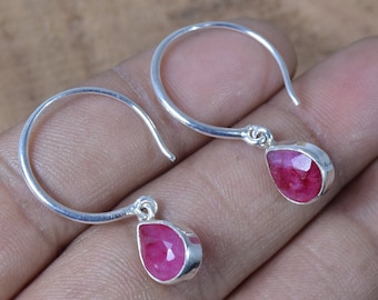 Pode incluir: Um par de brincos de argola de prata com pedras preciosas de rubi rosa em forma de lágrima que pendem da parte inferior.