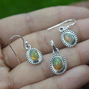 Puede incluir: Un conjunto de pendientes y un colgante de plata de ley con piedras preciosas de &oacute;palo de forma ovalada. Los pendientes tienen un cierre de gancho y el colgante tiene una anilla para sujetarlo a una cadena.