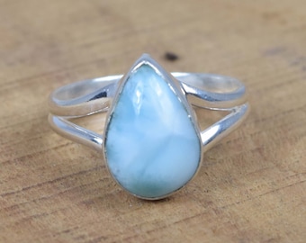 May include: A silver ring featuring a teardrop-shaped blue and white gemstone.