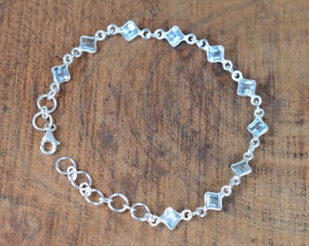 Könnte beinhalten: Ein silbernes Armband mit einem Kettenglieddesign und klaren quadratischen Edelsteinen.