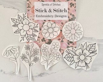 Könnte beinhalten: Acht schwarz-weiße Stickmuster auf weißem Papier. Die Muster umfassen verschiedene Blumen und Blätter. Das Papier ist mit "Stick & Stitch Embroidery Designs" beschriftet.