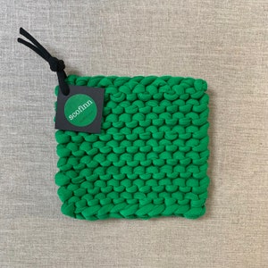 May include: Green knitted pot holder with a black tag that says "scofinn scofinn.com"