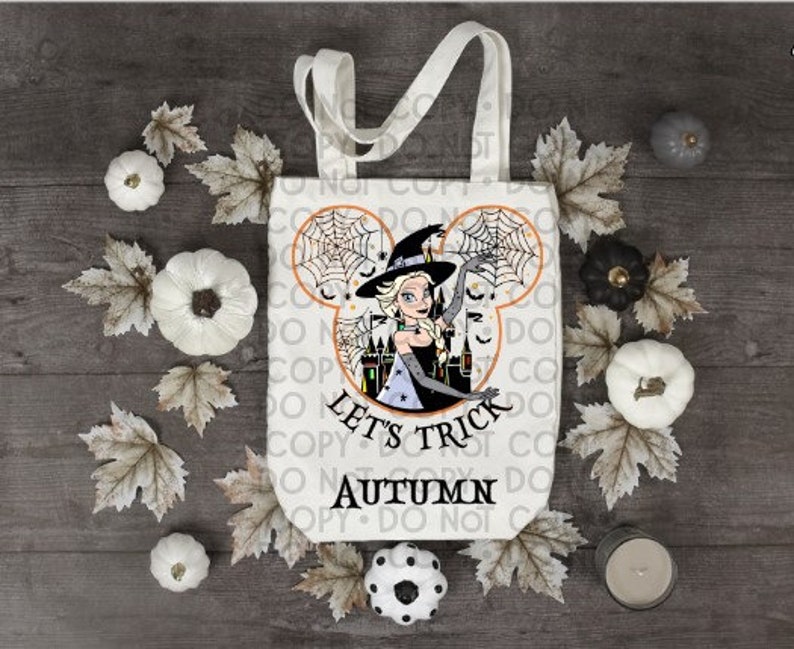 May include: White tote bag with a black and white illustration of a witch with a Mickey Mouse ear silhouette. The text "Let's Trick Autumn" is printed on the bag.