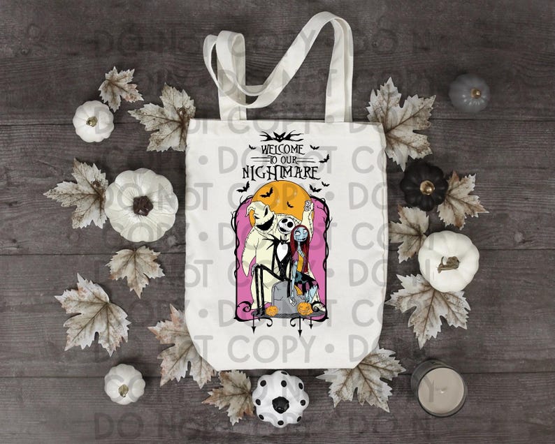 May include: A white canvas tote bag featuring a graphic print of Jack Skellington, Sally, and Oogie Boogie from The Nightmare Before Christmas. The text reads Welcome to our Nightmare, set against a yellow moon and pink background with bats.
