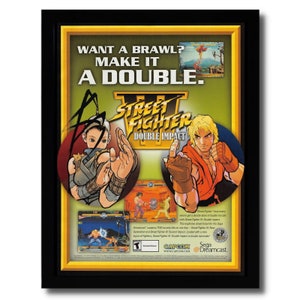 Puede incluir: Un anuncio vintage de videojuego para Street Fighter III: Double Impact en Sega Dreamcast. El anuncio presenta a dos personajes del juego, Chun-Li y Ryu, en una pose de lucha. El texto del anuncio dice "¿Quieres una pelea? Hazlo doble. Street Fighter III: Double Impact."