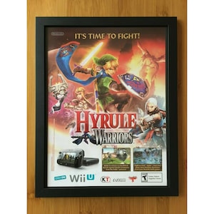 May include: A framed poster for the Nintendo Wii U game Hyrule Warriors. The poster features Link, Zelda, and other characters from the Legend of Zelda series. The text on the poster reads "It's time to fight!" and "Hyrule Warriors".