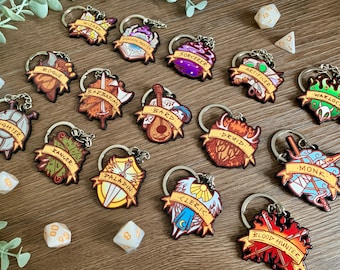 May include: A set of 15 colourful keychains featuring different Dungeons and Dragons character classes. Each keychain has a unique design with a class name and a symbol representing the class. The keychains are made of wood and have a silver metal ring.