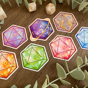 May include: A collection of seven die-cut stickers shaped like twenty-sided dice, each featuring a unique color gradient including purple, orange, green, pink, and blue, with gold-colored numbers and a thin white border around each sticker.