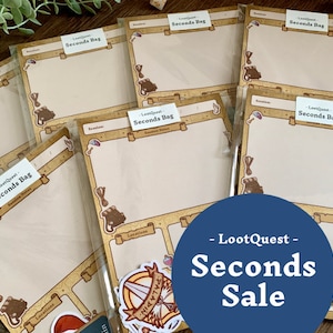 May include: A collection of blank notepads with a brown and gold border and the text "LootQuest Seconds Bag" printed on each notepad. The notepads are arranged in a stack on a wooden surface. The text "LootQuest Seconds Sale" is printed in blue on a blue circle in the lower right corner of the image.