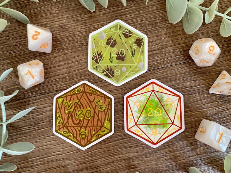 May include: Three hexagonal stickers shaped like twenty-sided dice. One sticker features a light green background with brown bear paw prints. Another shows a brown wood grain pattern. The third displays a bright green mossy texture inside red lines.