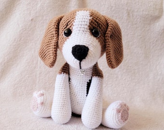May include: A crocheted beagle dog plush toy with brown and white fur, black nose, and black eyes. The dog is wearing a silver charm that says "my dog".
