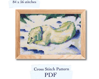 May include: Cross stitch pattern PDF for a sleeping polar bear in a snowy landscape. The pattern is 84 x 56 stitches.