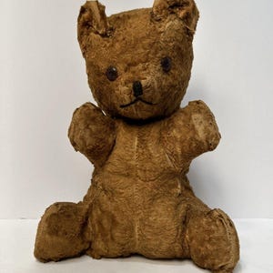 May include: A white ceramic mug with a black handle and the text "But First, Coffee" in a bold, black font. The mug is sitting on a wooden surface. The mug is approximately 4 inches tall.