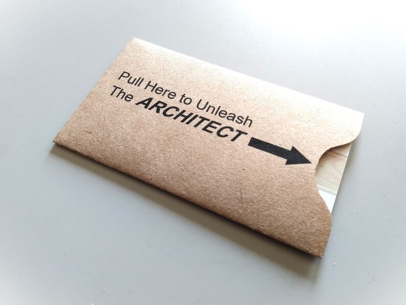 May include: A brown paper envelope with a black arrow pointing to the right. The text on the envelope reads 'Pull Here to Unleash The ARCHITECT'.