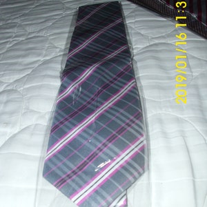 May include: A gray and pink striped tie with white stripes. The tie is packaged in a clear plastic bag.