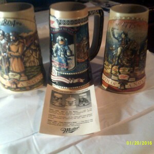 May include: Three ceramic beer steins with colorful illustrations depicting historical events. The steins feature the text "1804", "1776", and "A Nation's Birth".
