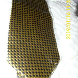 May include: A gold and black patterned tie. The tie has a checkered pattern with small squares.