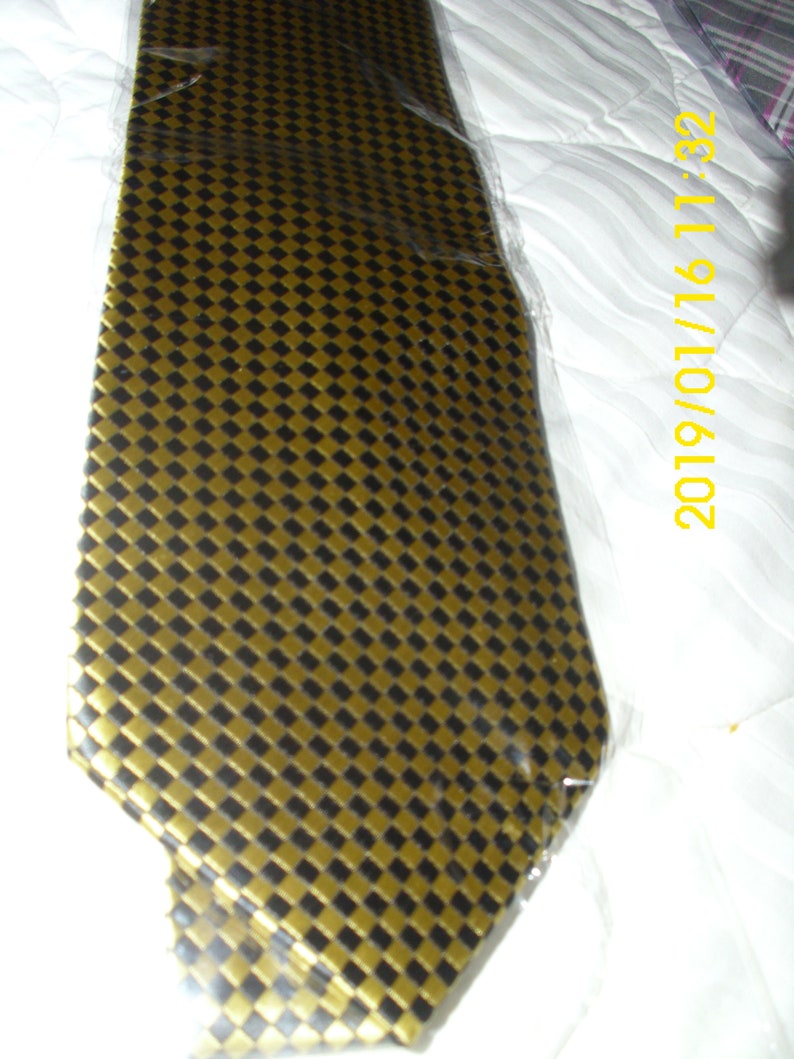 May include: A gold and black patterned tie. The tie has a checkered pattern with small squares.