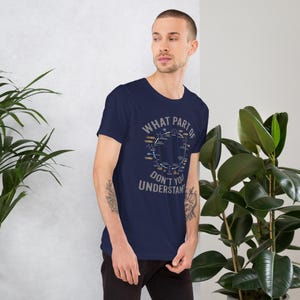 May include: Navy blue t-shirt with the text "WHAT PART OF DON'T YOU UNDERSTAND?" in a circular design. The design includes a diagram with various colors and shapes. The shirt is short-sleeved and made of a soft material.