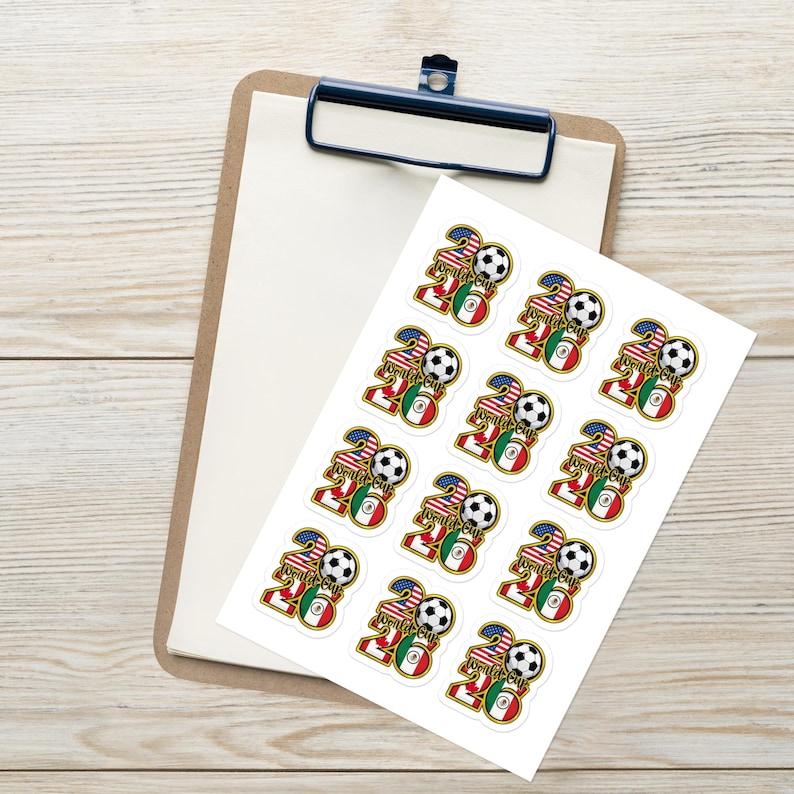 May include: A sheet of stickers featuring a soccer ball, the number 20, and flags of the United States and Mexico. The stickers are on a white sheet, resting on a wooden clipboard.