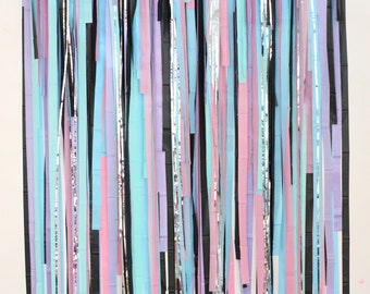 May include: A backdrop made of colourful paper streamers in shades of pink, blue, and black. The streamers are hanging from a white wall and are arranged in a random pattern.