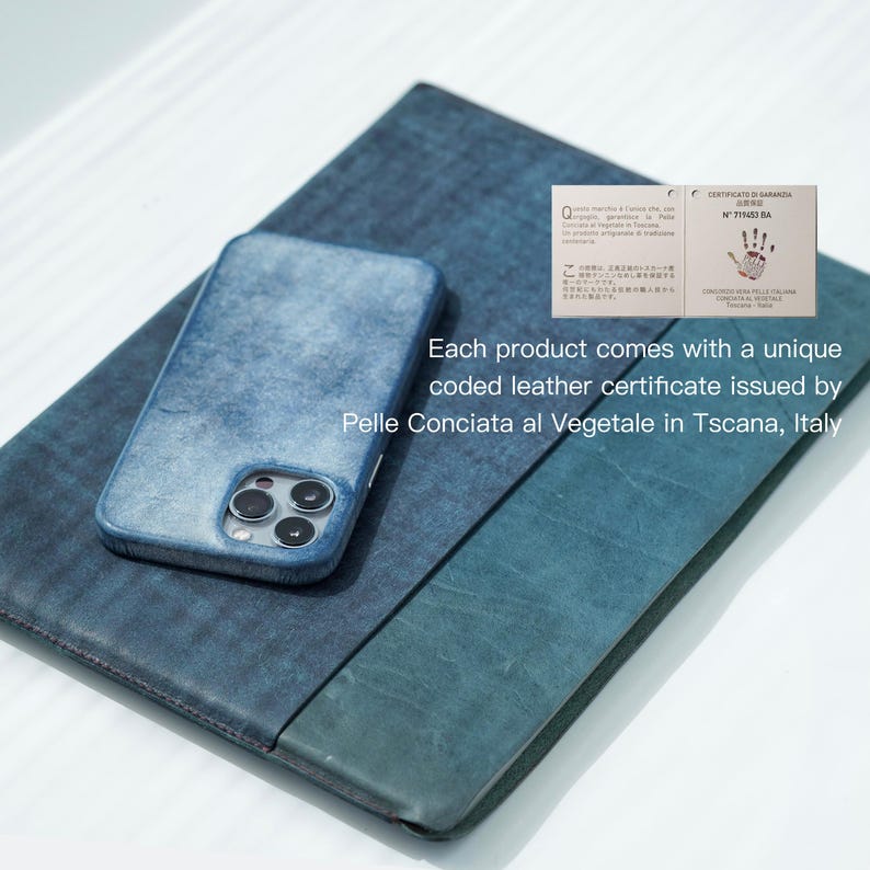 May include: A blue leather phone case and a matching folio are displayed on a light surface. The phone case is on top of the folio. The text on the image says, "Each product comes with a unique coded leather certificate issued by Pelle Conciata al Vegetale in Tscana, Italy."