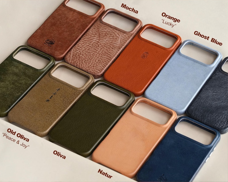 May include: A collection of leather phone cases in various colors, including brown, orange, blue, and green. Each case has a cutout for the camera and is labeled with a color name. Some cases have text that reads "Mocha", "Orange", "Ghost Blue", "Old Oliva", "Oliva", and "Natur".