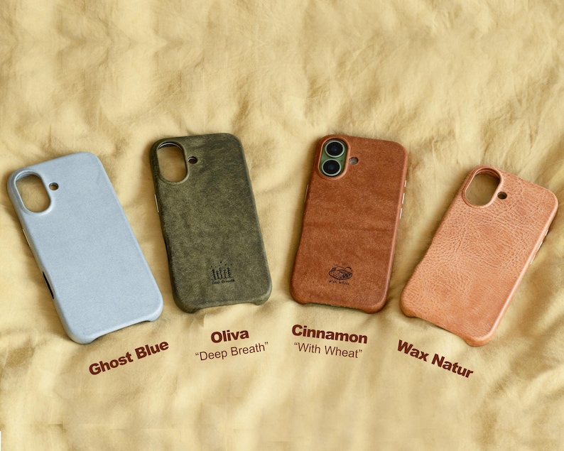 May include: Four phone cases in a row, each with a different color and texture. The colors are Ghost Blue, Oliva, Cinnamon, and Wax Natur. Each case has a cutout for the camera and buttons. The names of the colors are printed below each case.