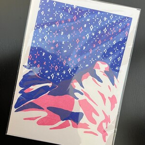May include: A pink and blue abstract print with a white background. The print features a stylized mountain range with a starry sky above.