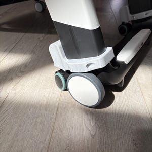 Peut inclure: Gros plan sur la base d'une chaise de bureau moderne avec des roulettes. Le cadre de la chaise est blanc et noir, avec des roues grises et blanches. Les roues sont conçues pour un mouvement fluide.