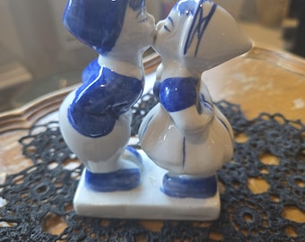 ヴィンテージの青いデルフト焼きの陶器で、男の子と女の子がキスをし